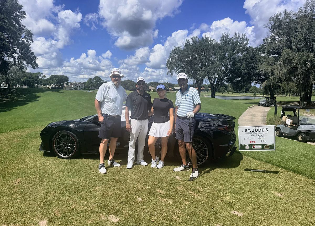 Michael T. Mackhanlall and his foursome at the 2026 St. Jude Charity Golf Tournament, Heathrow Country Club, beside the sponsor sign